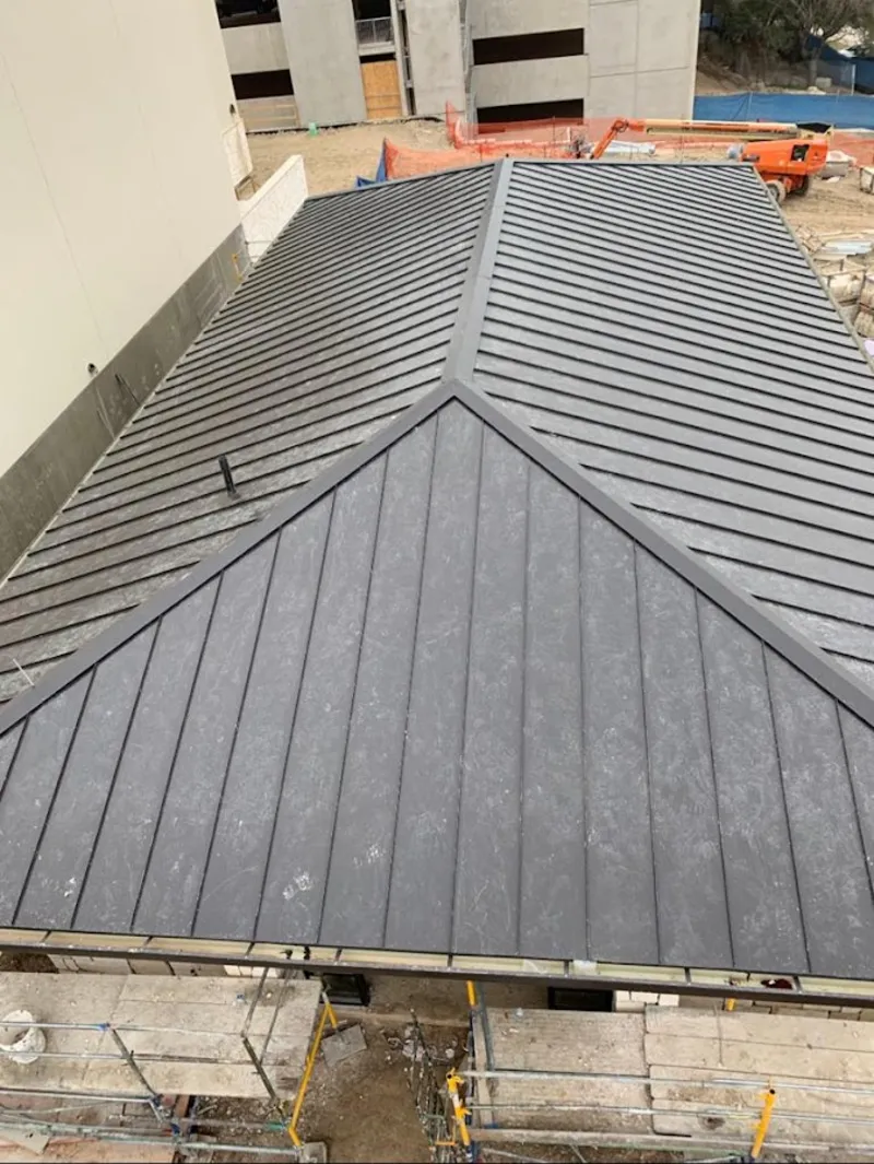 Commercial metal roof construction with crane equipment in Arlington